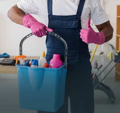 Cropped view of African american cleaner showing thumb up and holding bucket of detergents in office